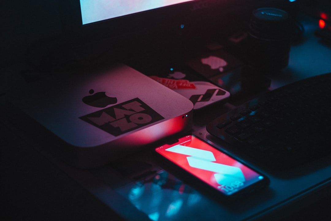 black smartphone turned-on in front of flat screen monitor